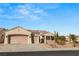 Single story home with two-car garage and desert landscaping at 3110 Scotts Valley Dr, Henderson, NV 89052