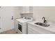 Laundry room with white cabinets, quartz countertops, and modern washer/dryer at 3110 Scotts Valley Dr, Henderson, NV 89052