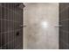 Modern shower with dark and light tile, built-in shelves, and rainfall shower head at 3314 El Camino Real, Las Vegas, NV 89121