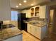 Galley-style kitchen with granite countertops and white cabinets at 4241 Gannet Cir # 205, Las Vegas, NV 89103