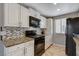 Kitchen featuring white cabinetry, granite countertops, and stainless-steel appliances at 4241 Gannet Cir # 205, Las Vegas, NV 89103