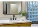 Modern bathroom with a marble countertop, black fixtures, and a glass block window at 4541 Largo Cantata St, Las Vegas, NV 89135