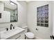 Modern bathroom with white vanity, black fixtures, and glass block window at 4541 Largo Cantata St, Las Vegas, NV 89135