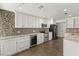 Modern kitchen with white cabinets, granite counters, and tile backsplash at 4840 Conough Ln, Las Vegas, NV 89149