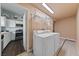 Functional laundry room with washer, dryer, shelving, and easy access to the kitchen at 504 Crony Ave, Henderson, NV 89011