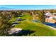 Aerial view of a golf course with pond and residential homes at 5305 Singing Hills Dr, Las Vegas, NV 89130