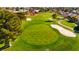 Aerial view of a green golf course with sand traps and trees at 5305 Singing Hills Dr, Las Vegas, NV 89130