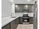 Modern kitchen with dark gray cabinets, white countertops, and stainless steel appliances at 59 E Agate Ave # 406, Las Vegas, NV 89123