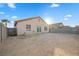 View of a dirt backyard enclosed by a block fence and the rear of the house at 610 Roberta Alecia Ave, North Las Vegas, NV 89031