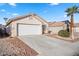 Inviting single-story home with a two-car garage, desert landscaping, and a mature palm tree at 610 Roberta Alecia Ave, North Las Vegas, NV 89031