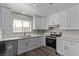 Bright kitchen with white cabinets, stainless steel appliances, and quartz countertops at 6412 Miragrande Dr, Las Vegas, NV 89108