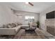 Virtually staged living room with sectional sofa and fireplace at 6412 Miragrande Dr, Las Vegas, NV 89108