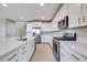 Modern kitchen with white cabinets, stainless steel appliances, and quartz countertops at 6828 Pacific Robin St, North Las Vegas, NV 89084