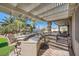 Outdoor kitchen with granite countertops and built-in grill under a pergola at 7131 Celadine St, Las Vegas, NV 89131