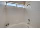 Clean bathroom featuring a bathtub with white tiles and a window for natural light at 7214 Paradise Bay Dr, Las Vegas, NV 89119