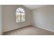 Well-lit bedroom with neutral walls and carpeting, plus an arched window at 7214 Paradise Bay Dr, Las Vegas, NV 89119