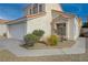 Exterior view of a home highlighting the manicured landscaping and a two-car garage at 7214 Paradise Bay Dr, Las Vegas, NV 89119