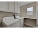 Laundry room with utility sink, front load washer and dryer, and white cabinets at 7214 Paradise Bay Dr, Las Vegas, NV 89119