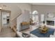 Open concept living room featuring a fireplace, wood floors, and staircase to the second floor at 7214 Paradise Bay Dr, Las Vegas, NV 89119