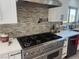 Modern kitchen with a large stainless steel range and white cabinets at 7221 Tempest Pl, Las Vegas, NV 89145