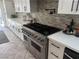 Modern kitchen with a large stainless steel range and white cabinets at 7221 Tempest Pl, Las Vegas, NV 89145