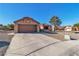 Beige home with desert landscaping, a two-car garage, and a red tile roof at 9037 Grayling Dr, Las Vegas, NV 89134