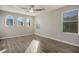 Bright bedroom with wood-look floors, ceiling fan, and multiple windows at 9328 Black Wolf Ave, Las Vegas, NV 89178