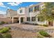 Landscaped backyard with stone accents, lush greenery, covered patio, and outdoor grill at 9625 Ponderosa Skye Ct, Las Vegas, NV 89166