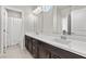 Well-lit bathroom with dual sinks, dark wood cabinets, and a large mirror at 9625 Ponderosa Skye Ct, Las Vegas, NV 89166