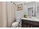 Half bathroom features neutral paint, vanity with dark wood cabinets, tile flooring and a decorative mirror at 9625 Ponderosa Skye Ct, Las Vegas, NV 89166