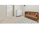 Cozy Bedroom featuring a wooden crib, white dresser, and stylish rug on plush carpet at 9625 Ponderosa Skye Ct, Las Vegas, NV 89166