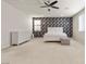 Spacious bedroom featuring neutral carpeting, decorative accent wall, ceiling fan and a large dresser at 9625 Ponderosa Skye Ct, Las Vegas, NV 89166