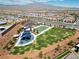 Aerial view of a community park with a playground, basketball court, green space, and walking paths at 9625 Ponderosa Skye Ct, Las Vegas, NV 89166