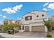 Two-story house with beige exterior, two-car garage, and landscaping at 9625 Ponderosa Skye Ct, Las Vegas, NV 89166