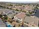 Aerial view showing desert landscaping, covered patio, pool, and many neighboring houses at 9625 Ponderosa Skye Ct, Las Vegas, NV 89166