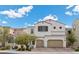 Two-story house with beige exterior, two-car garage, and landscaping at 9625 Ponderosa Skye Ct, Las Vegas, NV 89166