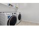 Well-lit laundry room featuring a modern washer and dryer, neutral paint and tile flooring at 9625 Ponderosa Skye Ct, Las Vegas, NV 89166