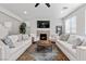 Inviting living room featuring a cozy fireplace, comfortable sofas, and a stylish ceiling fan at 9625 Ponderosa Skye Ct, Las Vegas, NV 89166