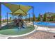 Community playground featuring covered play equipment and splash pad for outdoor fun at 9625 Ponderosa Skye Ct, Las Vegas, NV 89166