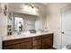 Double vanity bathroom with brown cabinets and a large mirror at 10456 Skye Knoll Ave, Las Vegas, NV 89166