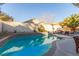 Beautiful backyard pool surrounded by desert landscaping and patio furniture at 1308 Royal Creek Ct, North Las Vegas, NV 89031