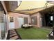 Charming patio space with turf, stone walkway, and outdoor seating under a shade covering at 1409 E St Louis Ave # A, Las Vegas, NV 89104