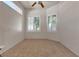 Bright bedroom with tile flooring, a ceiling fan, and two windows with plantation shutters at 2101 Desert Woods Dr, Henderson, NV 89012