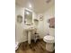 Clean bathroom with a pedestal sink, toilet, and wood-look flooring at 2412 Twin Flower Cir, Las Vegas, NV 89134