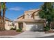 Two-story house with tan exterior, solar panels, and a two-car garage at 2412 Twin Flower Cir, Las Vegas, NV 89134