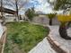 Landscaped backyard with grassy area, stone pathway, and mature trees at 2621 Slide Canyon Ave, North Las Vegas, NV 89081