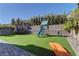 Artificial turf backyard with playset, trampoline, and additional slide at 319 Cooper Hawk Ct, Las Vegas, NV 89138