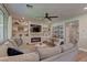 Living room with a sectional sofa, fireplace, and large windows at 319 Cooper Hawk Ct, Las Vegas, NV 89138