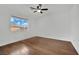 Inviting bedroom featuring hardwood floors, a ceiling fan, and a window overlooking a residential area at 3891 Terrazzo Ave, Las Vegas, NV 89115