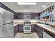 Functional kitchen with stainless steel appliances, dark cabinetry, and a corner sink, maximizing space and efficiency at 3891 Terrazzo Ave, Las Vegas, NV 89115